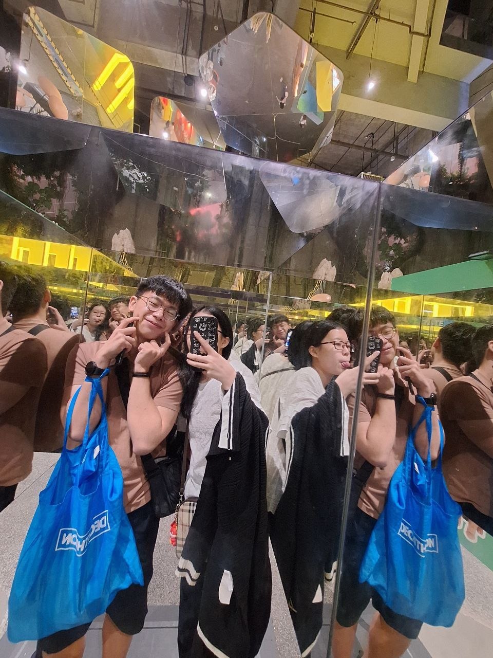 Rey and Feli taking a playful mirror selfie together inside a room full of reflections