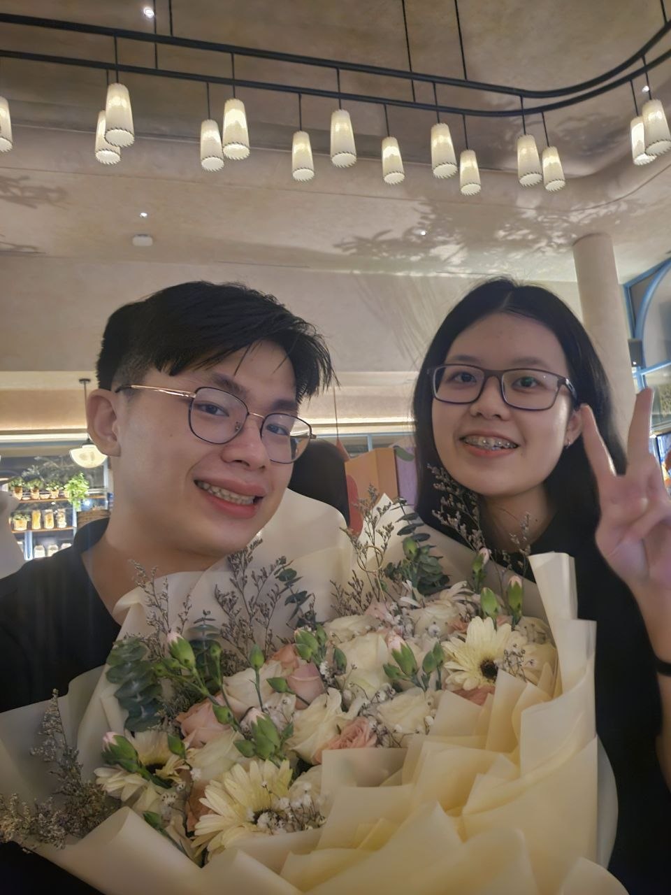 Rey and Feli smiling with a large bouquet during a date night