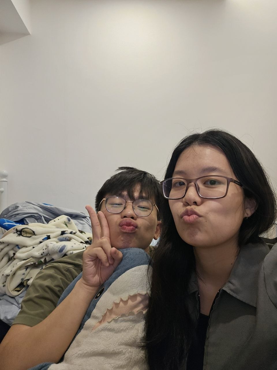 Rey and Feli taking a cozy selfie indoors while making playful kiss faces