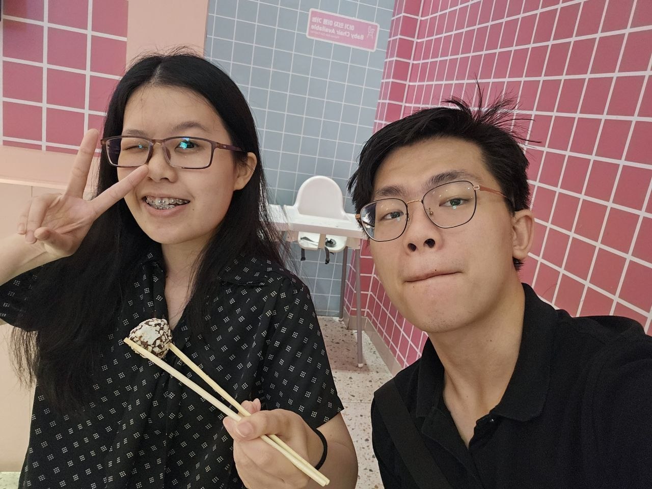 Rey and Feli at a dessert cafe, holding a sweet treat for the camera